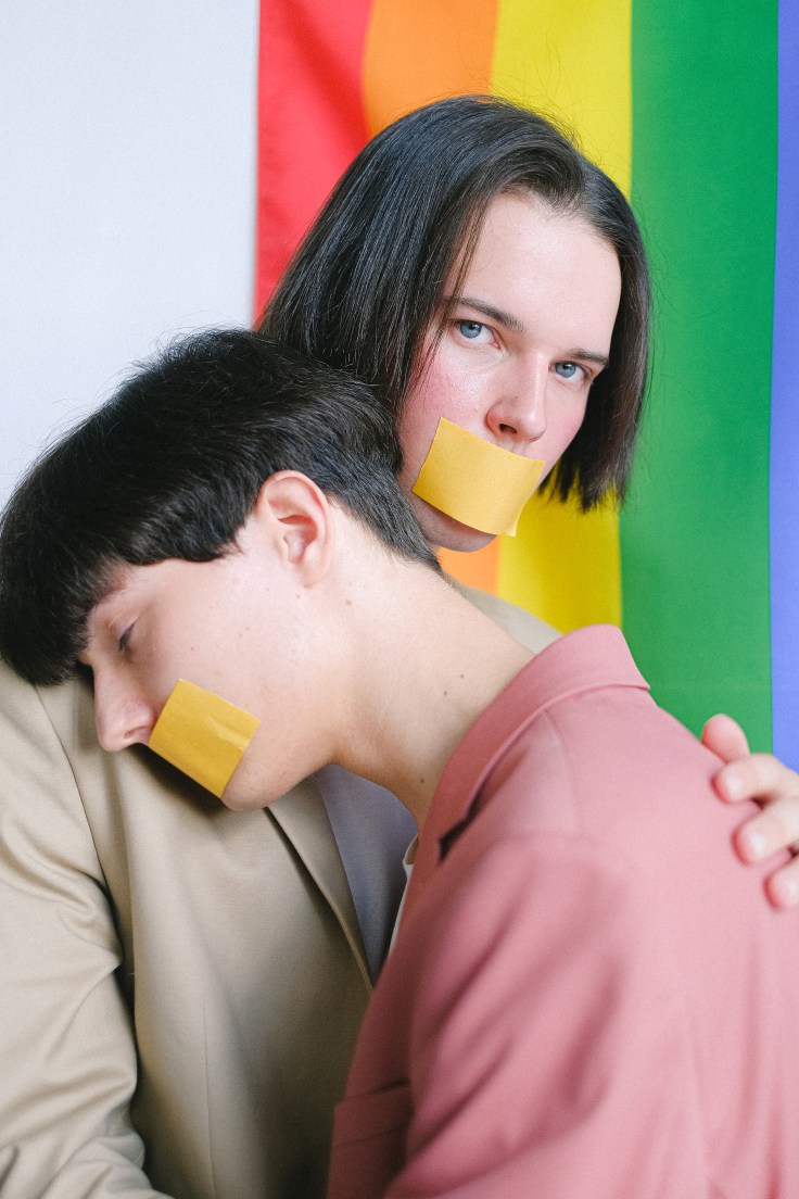 two-men-with-adhesive-tape-over-their-mouth-hugging-4611699